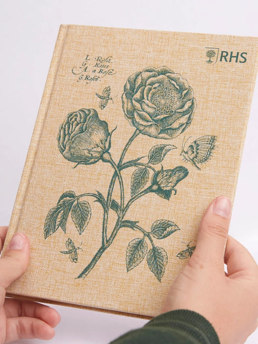 Notebook with floral design and RHS logo held by hands on a light background