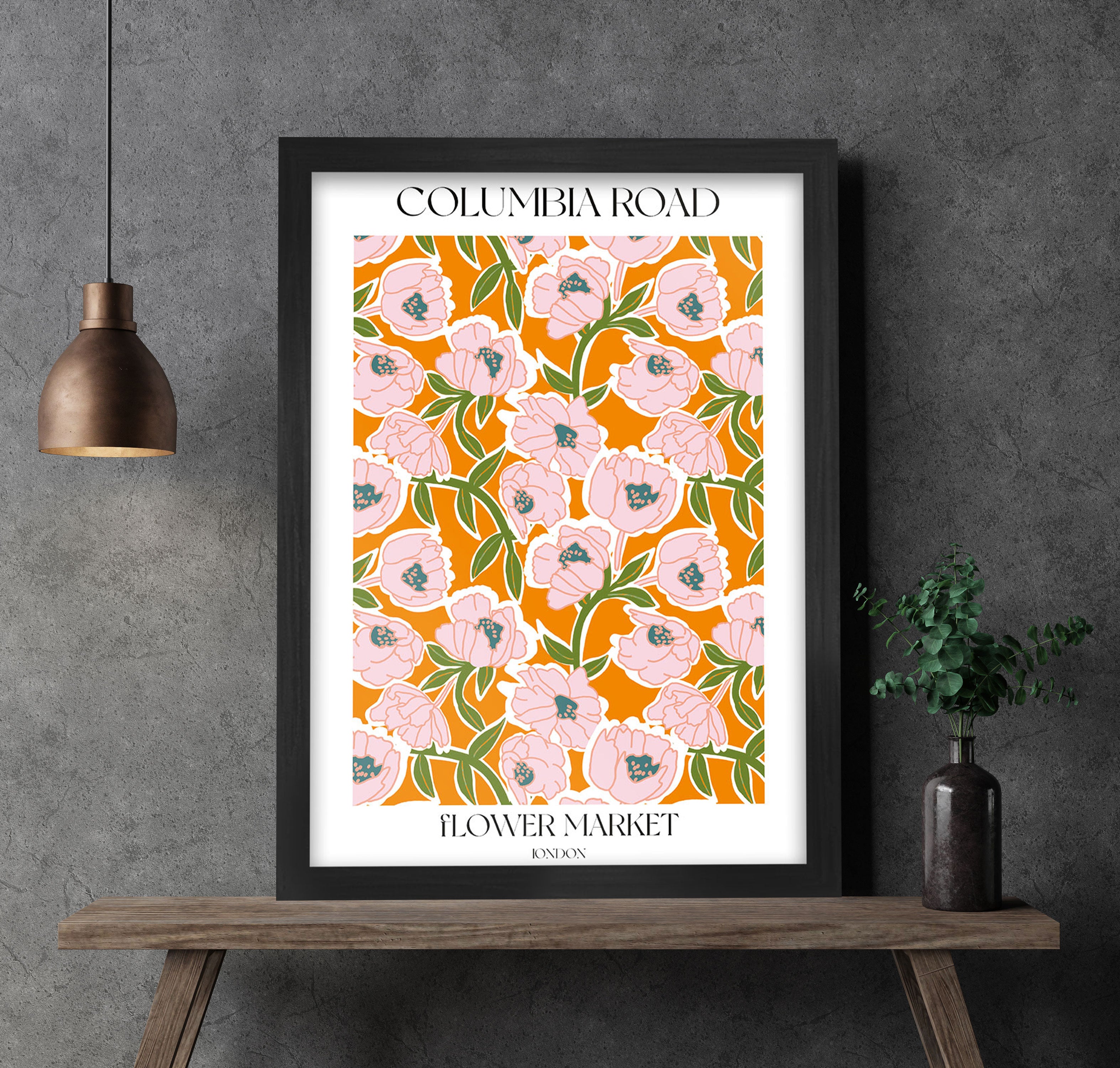 Framed Columbia Road Flower Market poster with floral design on a gray wall.