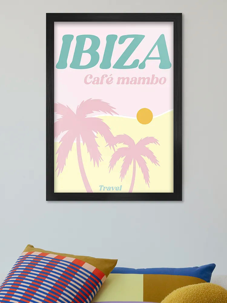 Framed poster with 'IBIZA Café mambo' text and palm trees on a light background, leaning against a wall with colorful pillows.