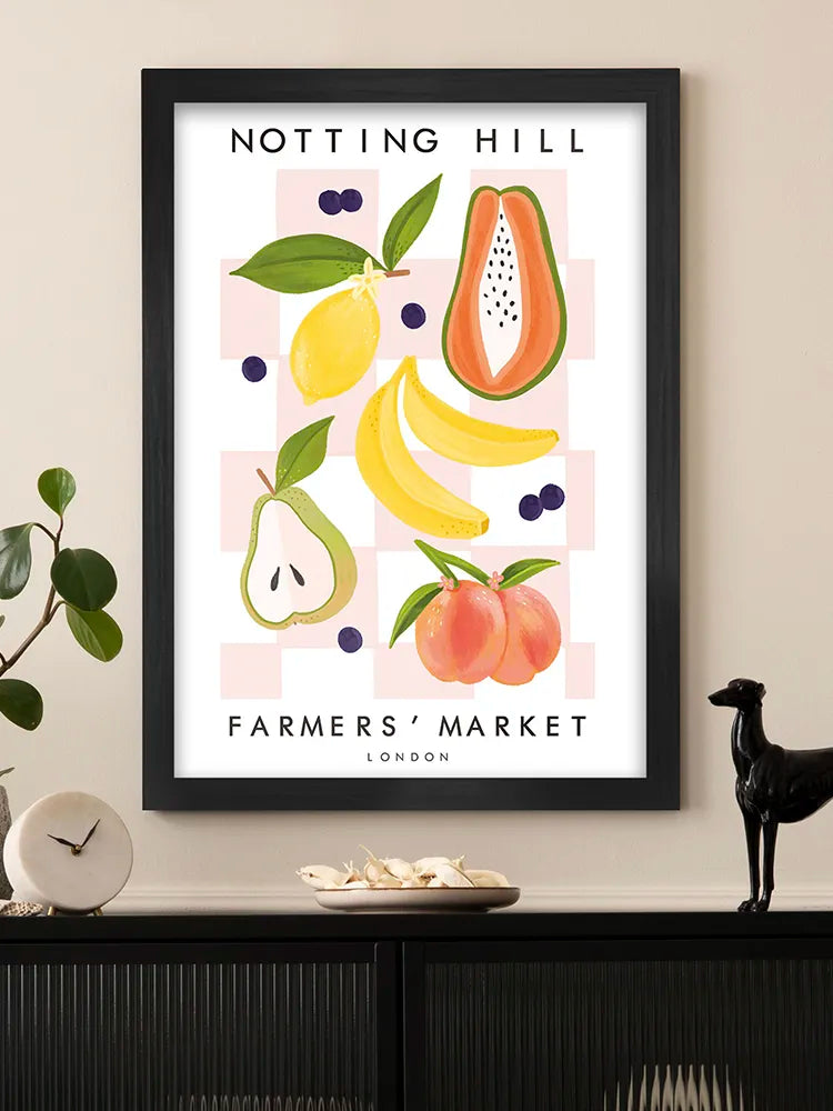 Framed artwork of fruits with 'Notting Hill Farmers' Market, London' text on a wall.