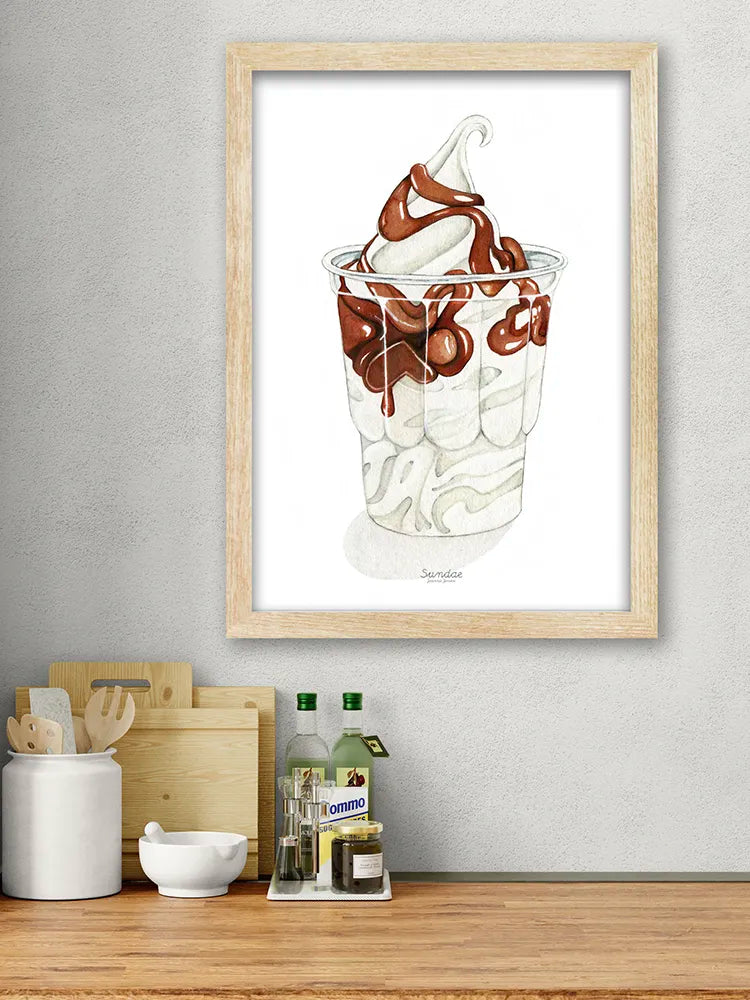 Framed artwork of a dessert in a glass on a kitchen counter.