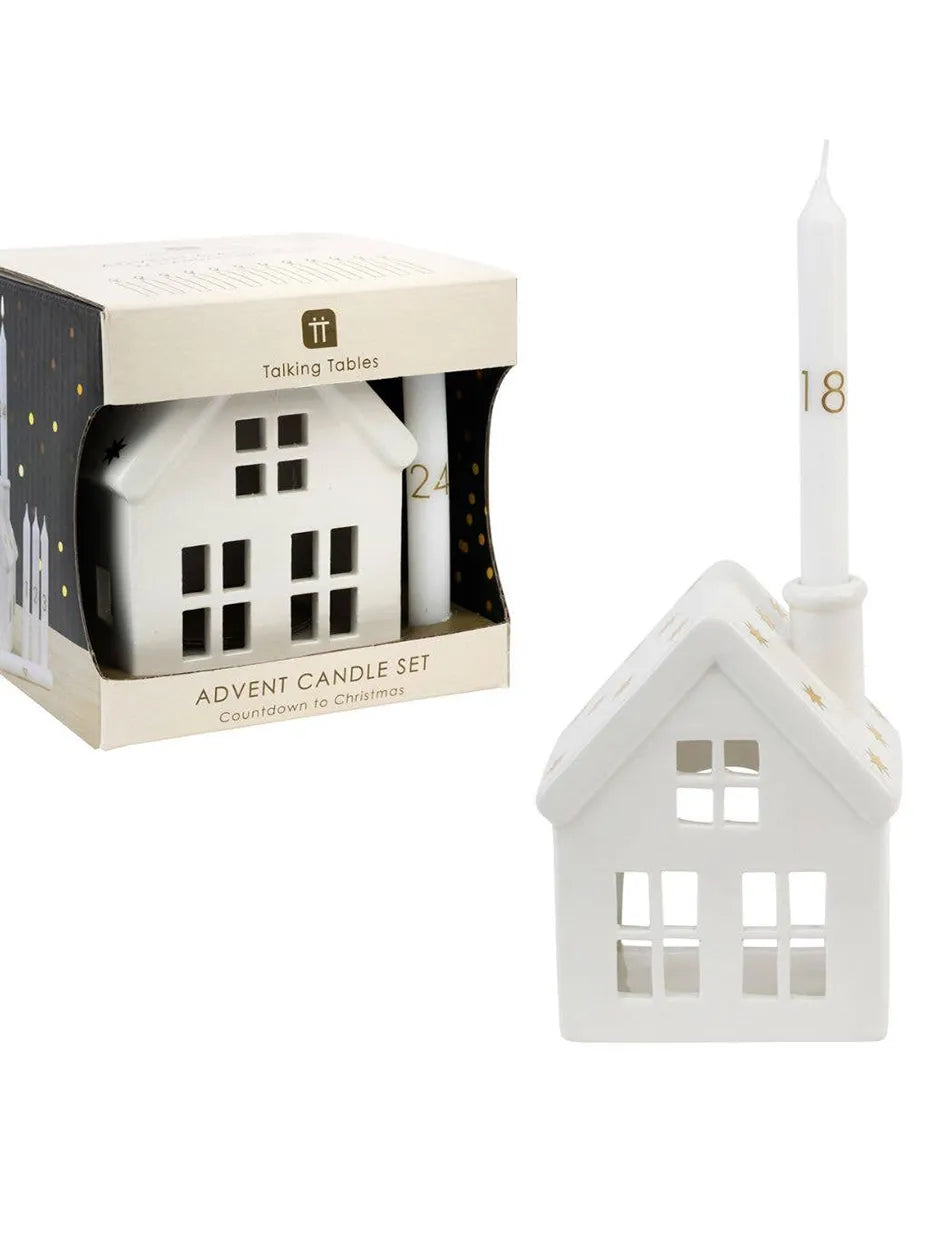 A ceramic house candle holder with numbered advent candles, designed to mark the countdown to Christmas.