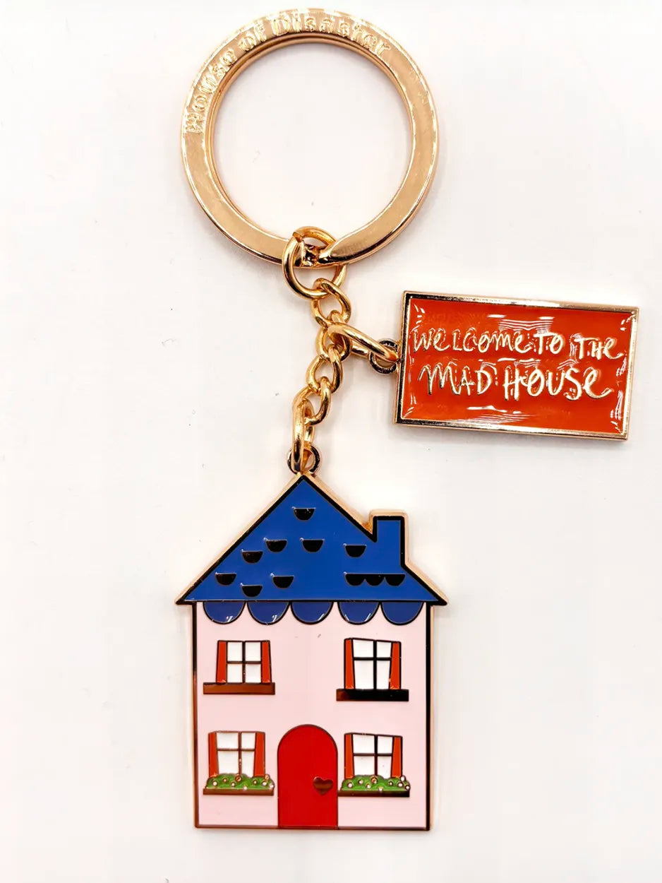 This cute metal keyring is finished in enamel. It features the slogan 'welcome to the madhouse'.