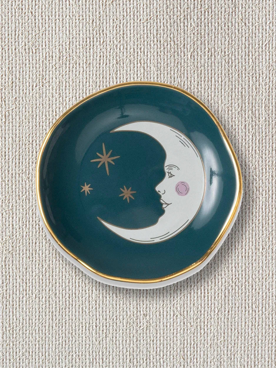 This ceramic trinket tray features a celestial design, depciting the moon and stars. it's perfect for holding jewellery, keys, or small keepsakes.