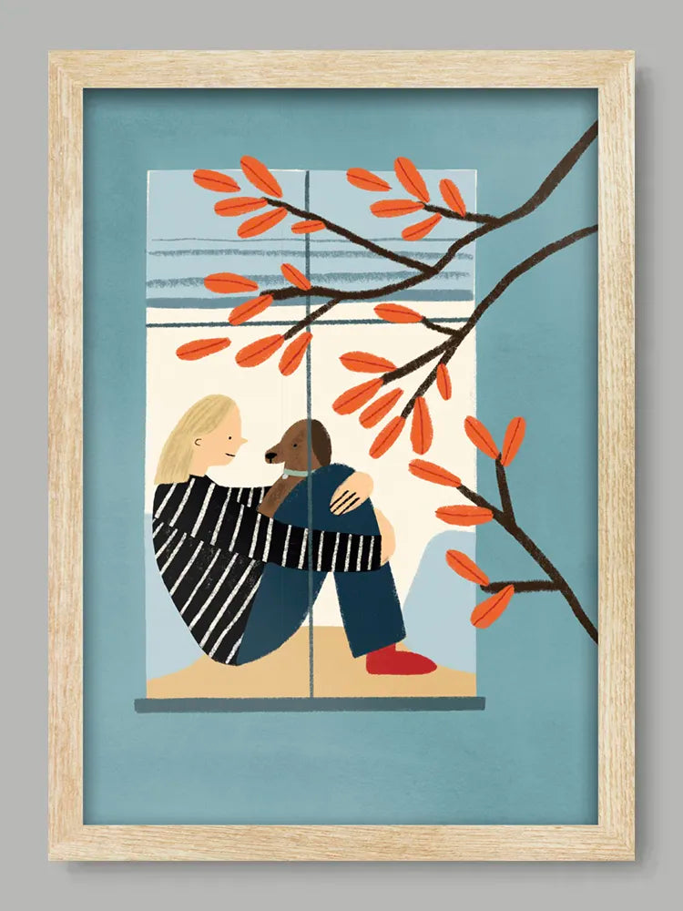 Framed artwork of two people embracing by a window with autumn leaves.